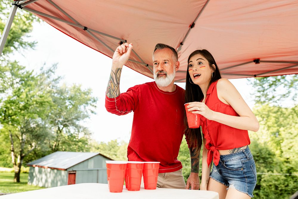 Couple playing beer pong at a tailgate party