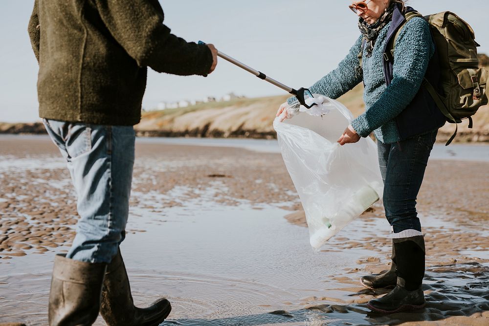 Beach cleanup volunteers picking up trash for environment campaign