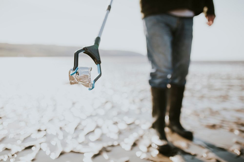 Beach cleanup volunteers picking up trash for environment campaign