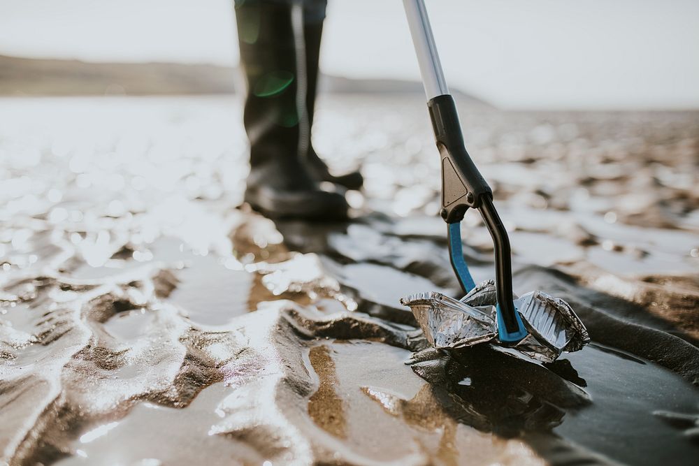 Beach cleanup volunteers picking up trash for environment campaign