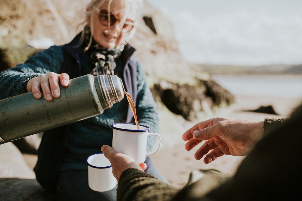 Senior woman pouring coffee into a camping mug