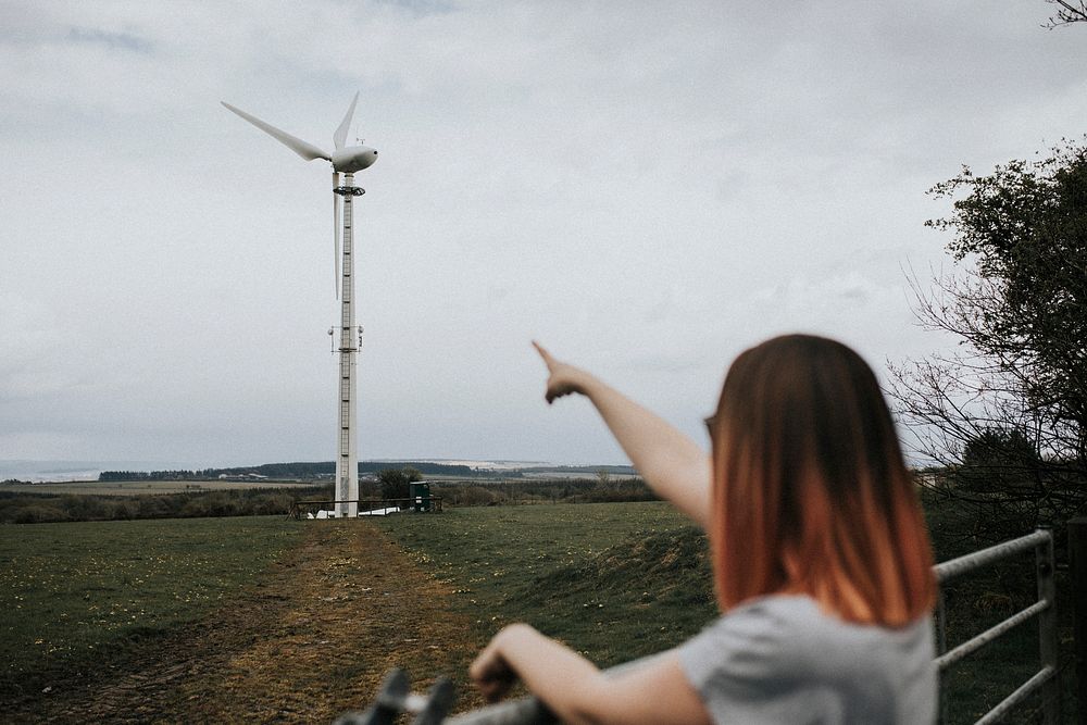 Woman pointing at a wind turbine