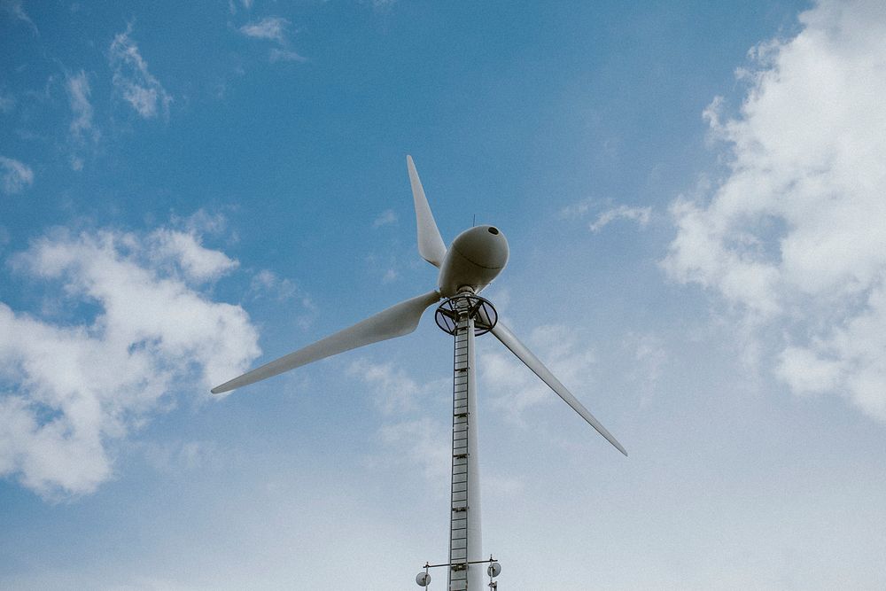 Wind turbine under blue sky renewable energy environmental campaign