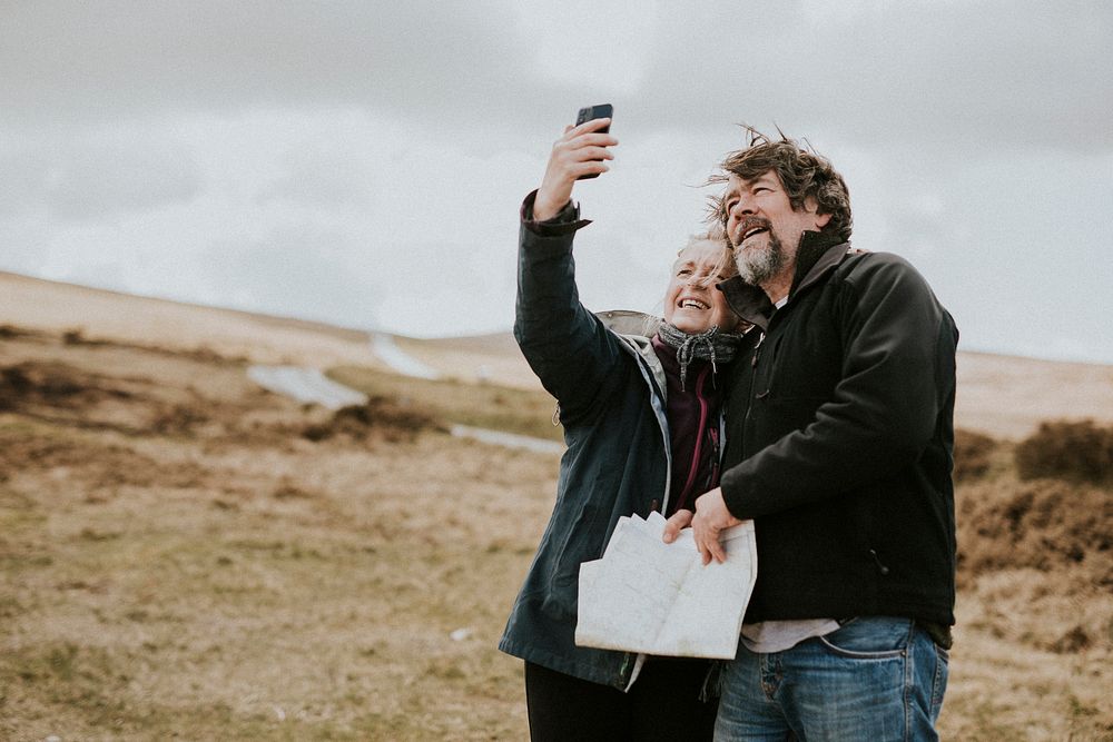 Senior happy couple taking selfies in Wales, UK