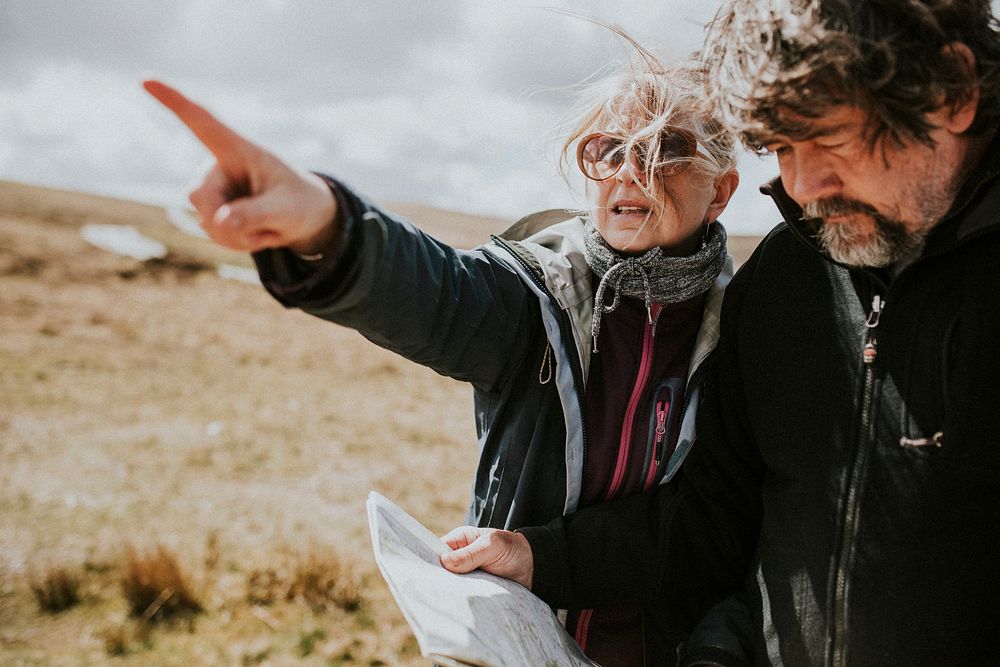 Senior tourist couple looking at the map while being lost in Wales, UK