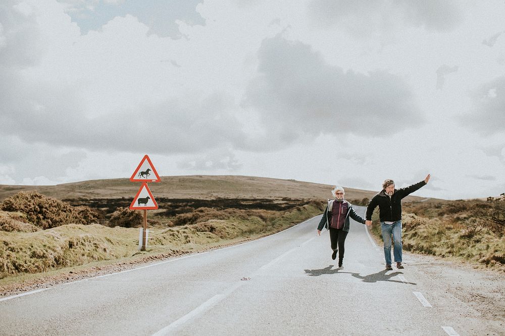 Happy senior tourist couple on the highway in Wales, UK