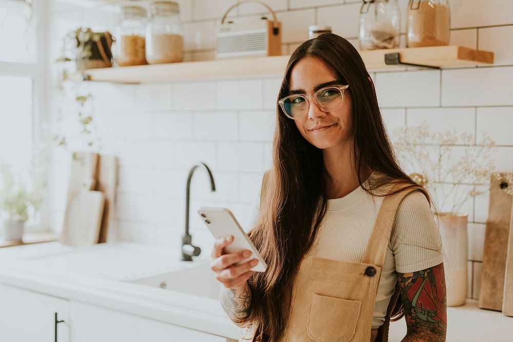 Lifestyle blogger using her mobile phone in the kitchen