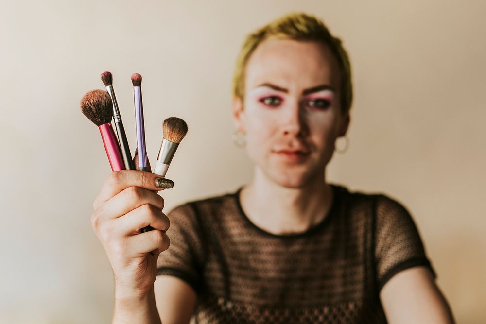 Non-binary beauty blogger with makeup tools