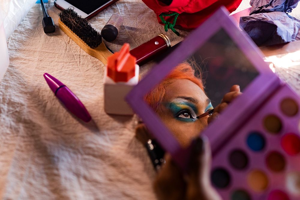 Man in drag applying eyeshadow, entertainment makeup look