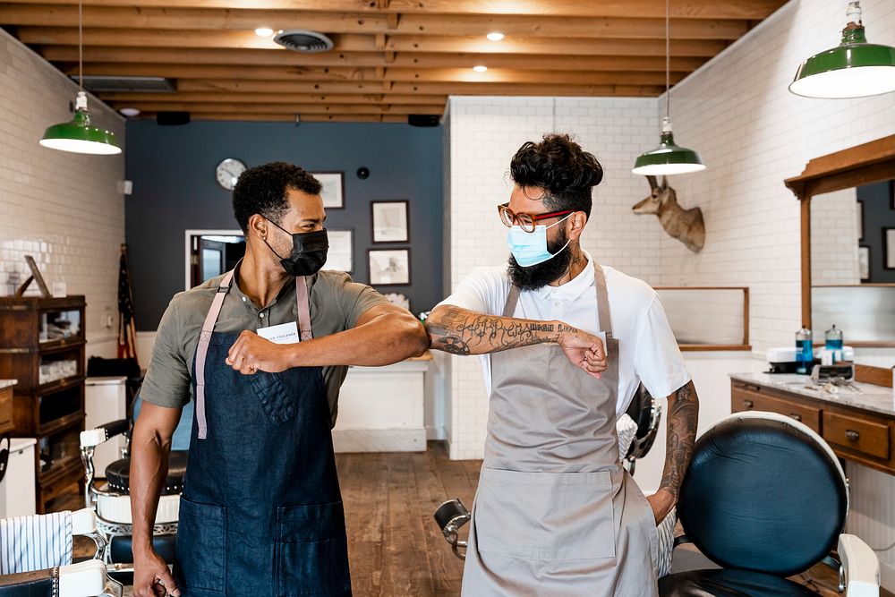 Barbers in face masks doing elbow bumps, business in the new normal