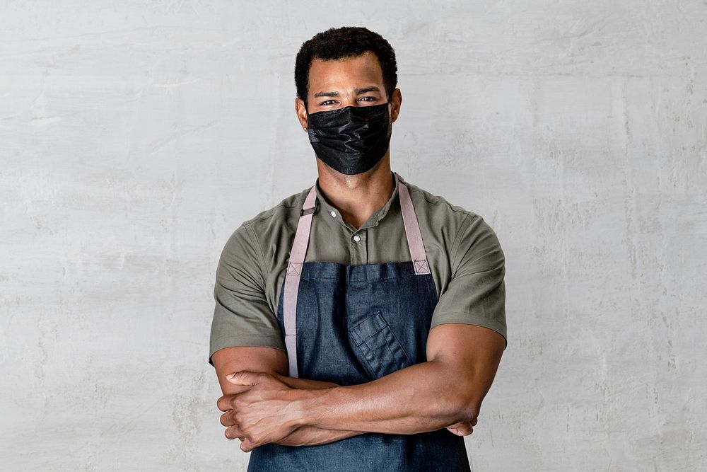 Man in face mask wearing denim apron, small business in the new normal