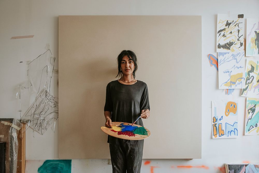 Woman artist mixing paint on a color palette