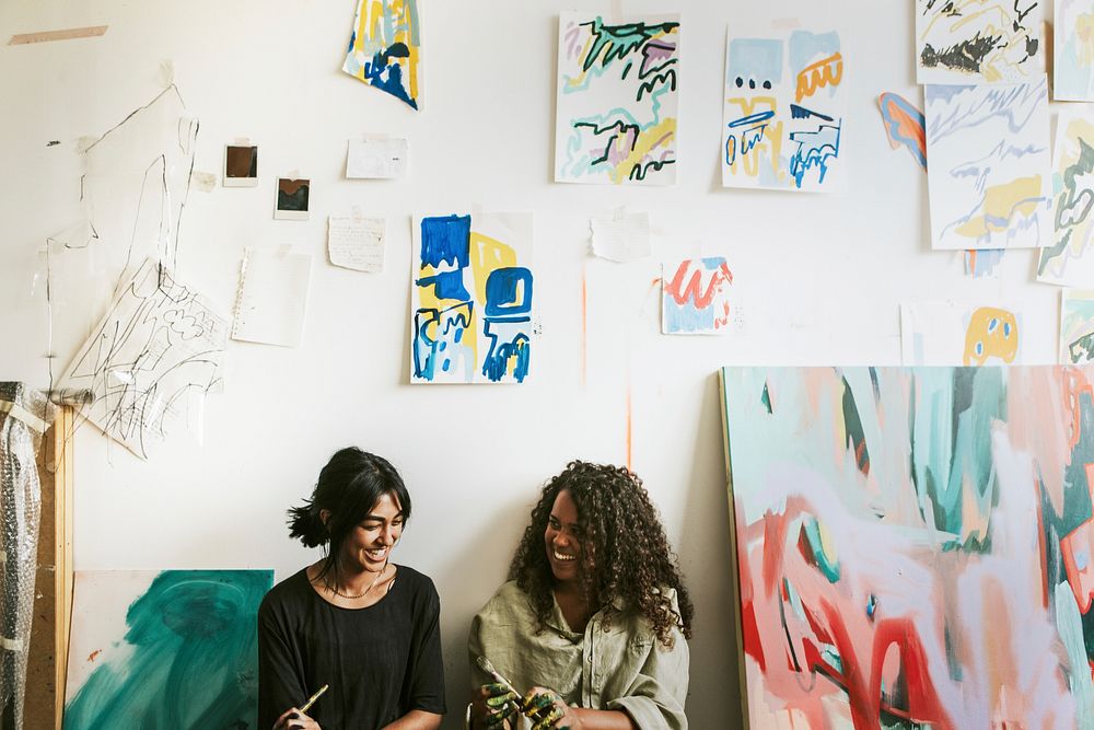 Woman artist friends exchanging ideas in their studio 