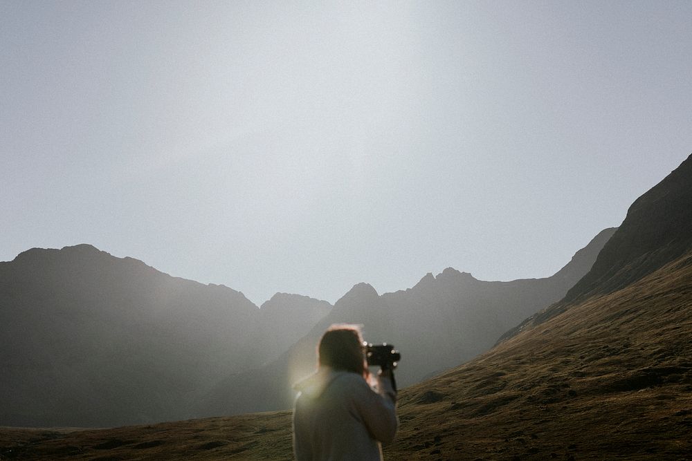 Retro video camera, traveler in Scottish nature