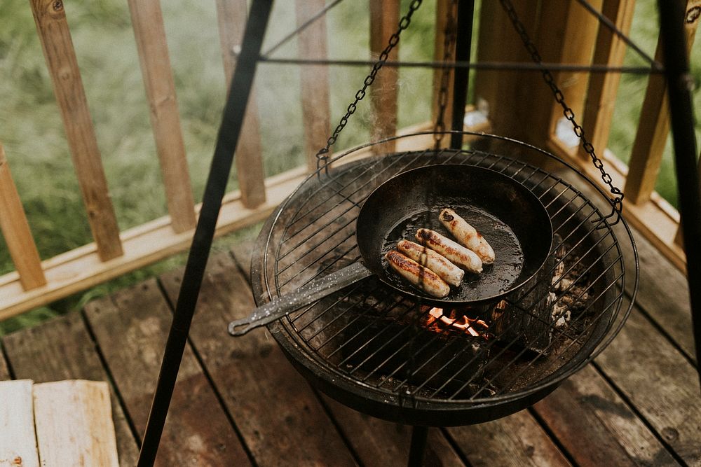 Grilling sausages over fire, rustic food