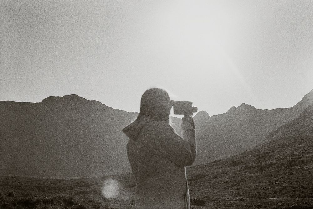 Retro video camera, traveler in Scottish nature