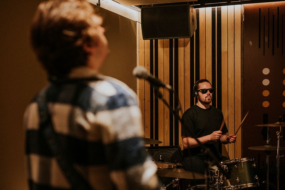 Rock band drummer performing repetition in recording studio