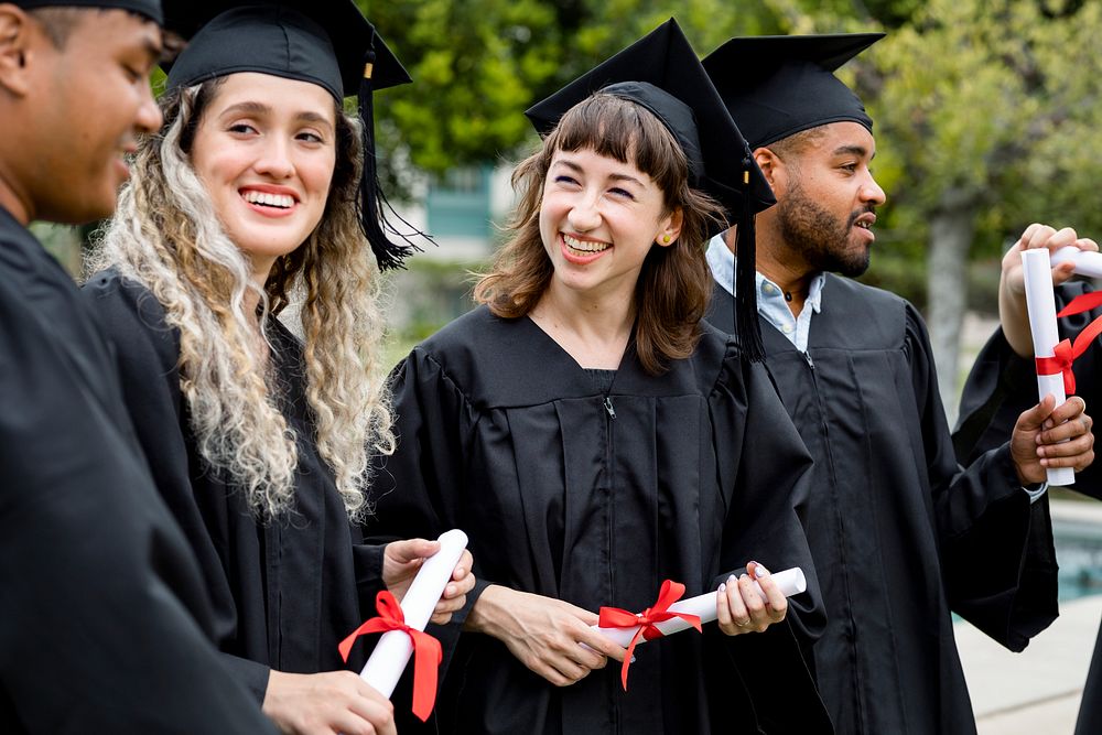 Happy students graduating university, celebrating with diplomas