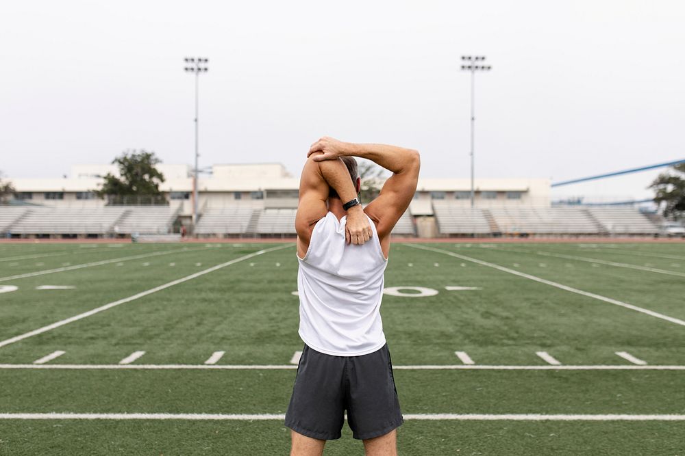 Man warming up by stretching before exercise