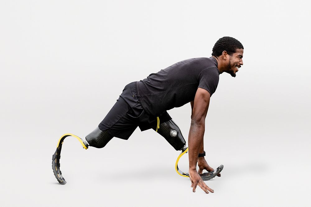 Paralympic athlete with prosthetic legs warming up by stretching before exercising