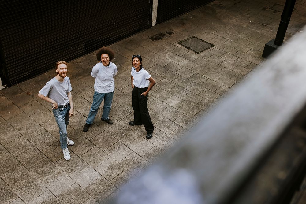 Three diverse friends looking up from the alley