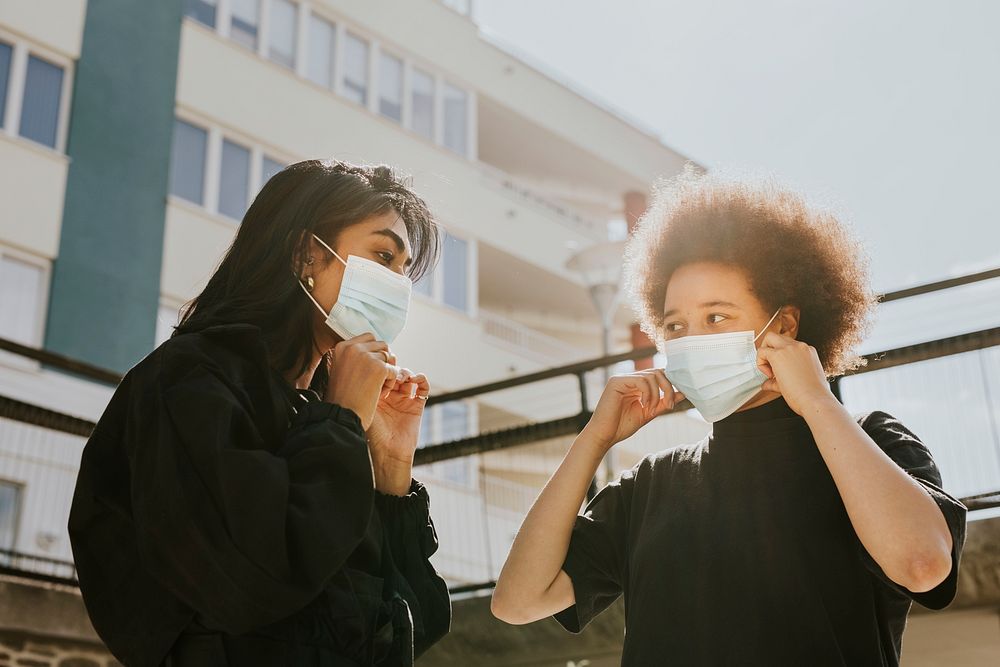 Two women wearing surgical masks in public