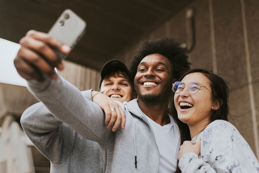 Diverse friends taking selfie from phone
