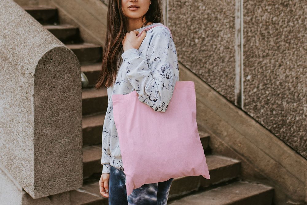 Woman using tote pink bag, standing by the staircase