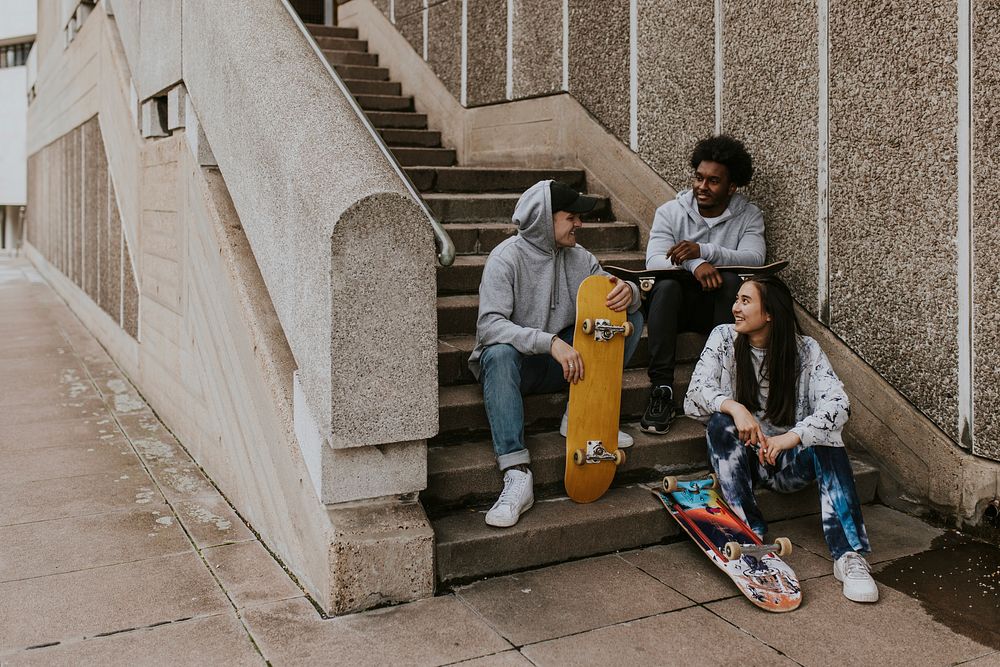 Diverse skaters talking and sitting at staircase