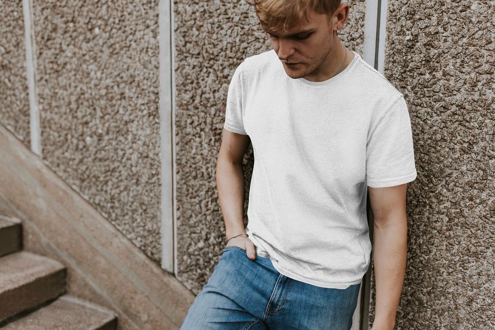 Cool man in white tee and jeans at staircase