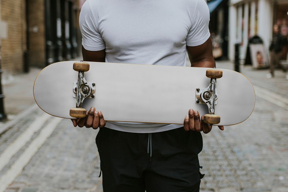 Man with white skateboard in town