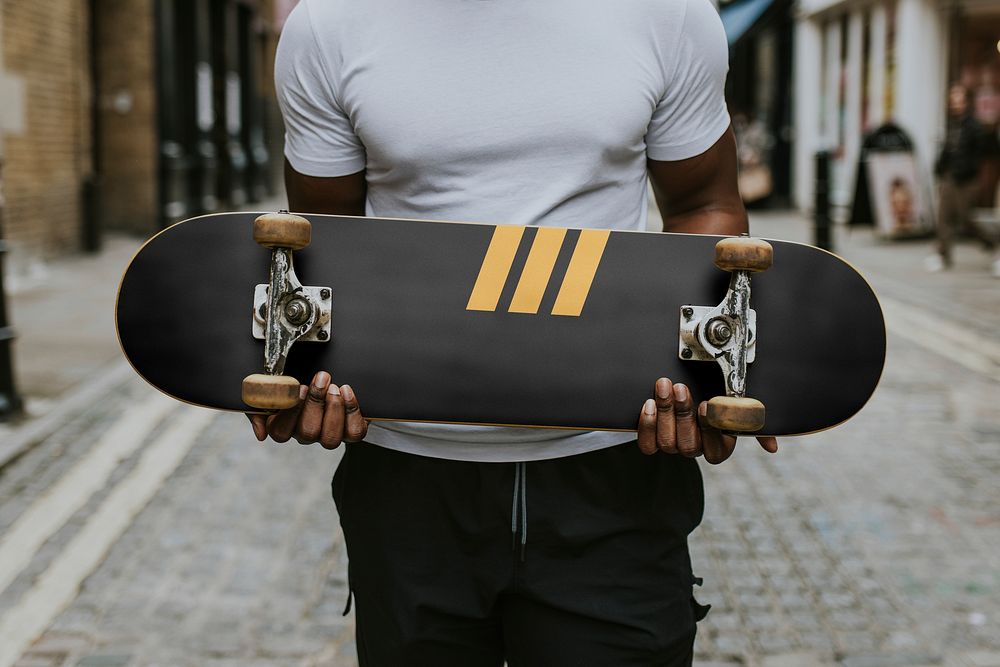 Man holding cool black and yellow skateboard