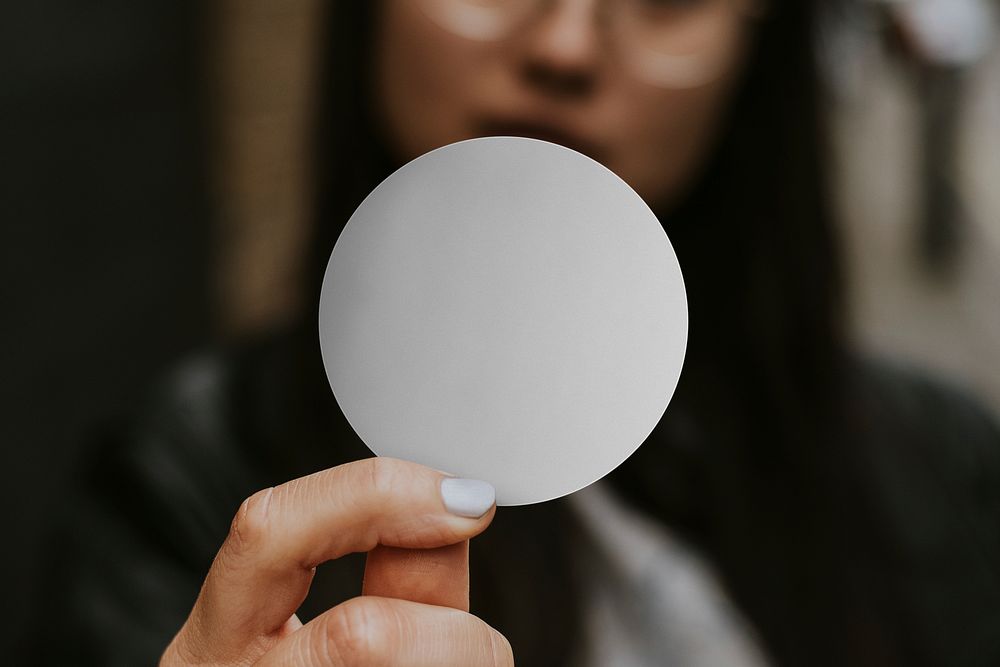 Blank round gray sticker, held by woman