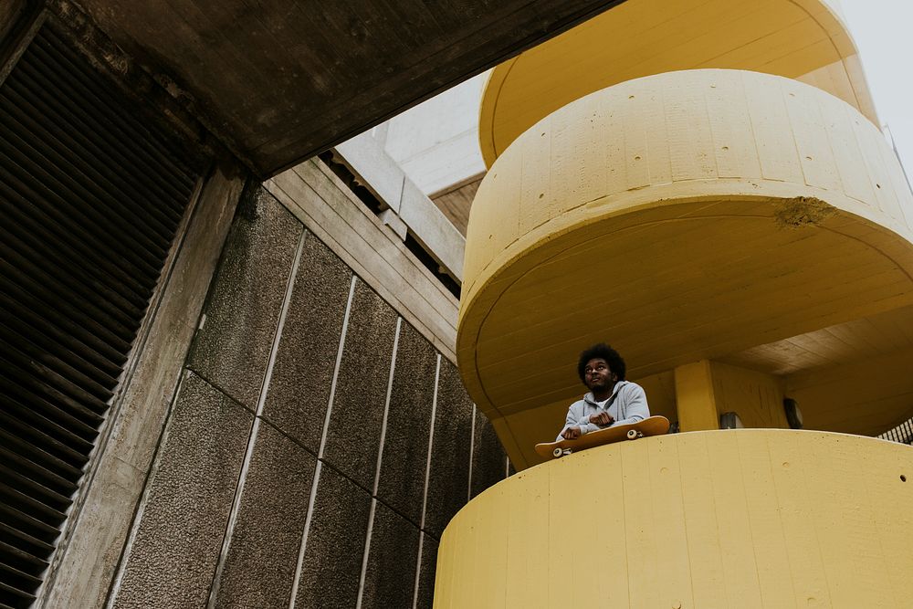 Man with skateboard at yellow stairs