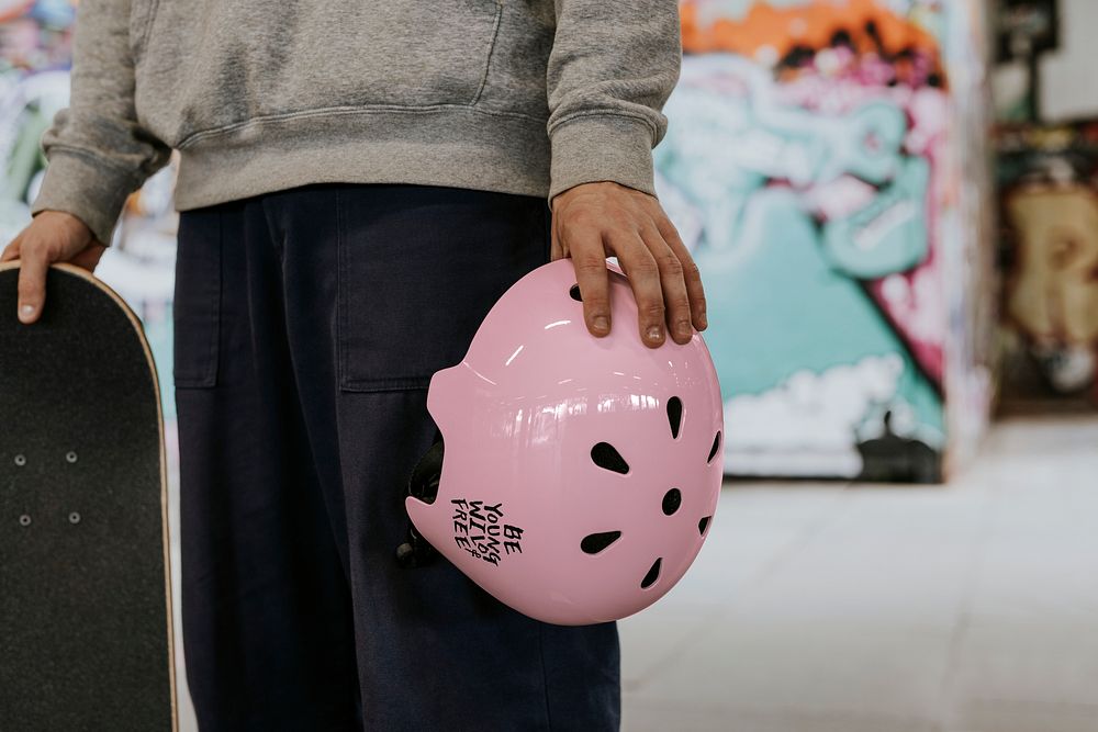Pink skate helmet mockup, sports safety equipment, held by man psd
