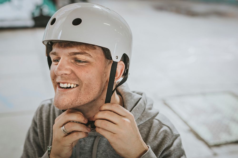 Cheerful skate wearing white helmet, sports safety equipment