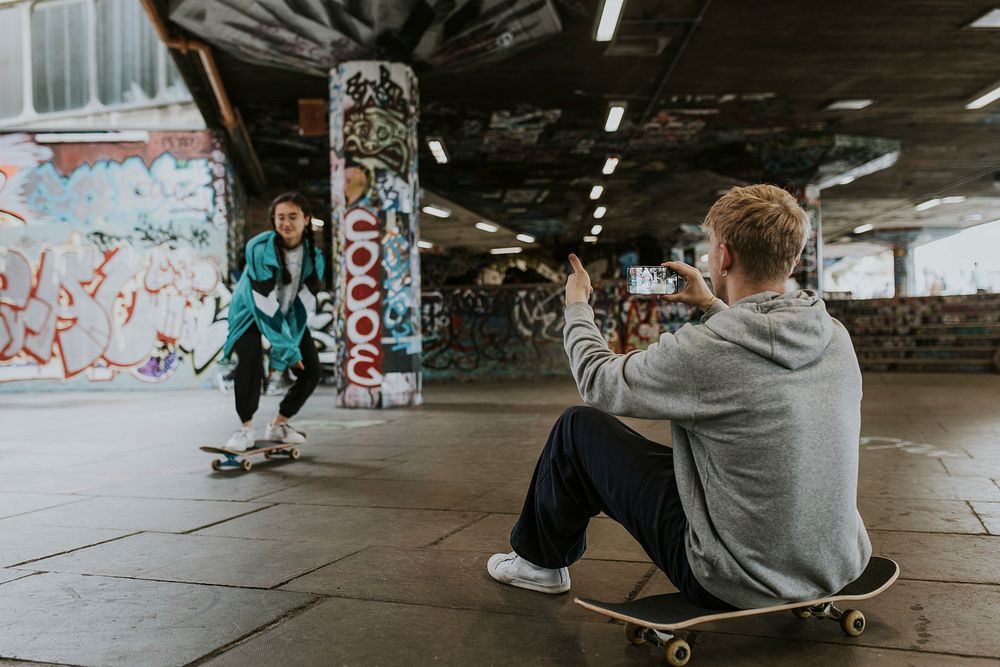 Female skater being captured by friend at skate park