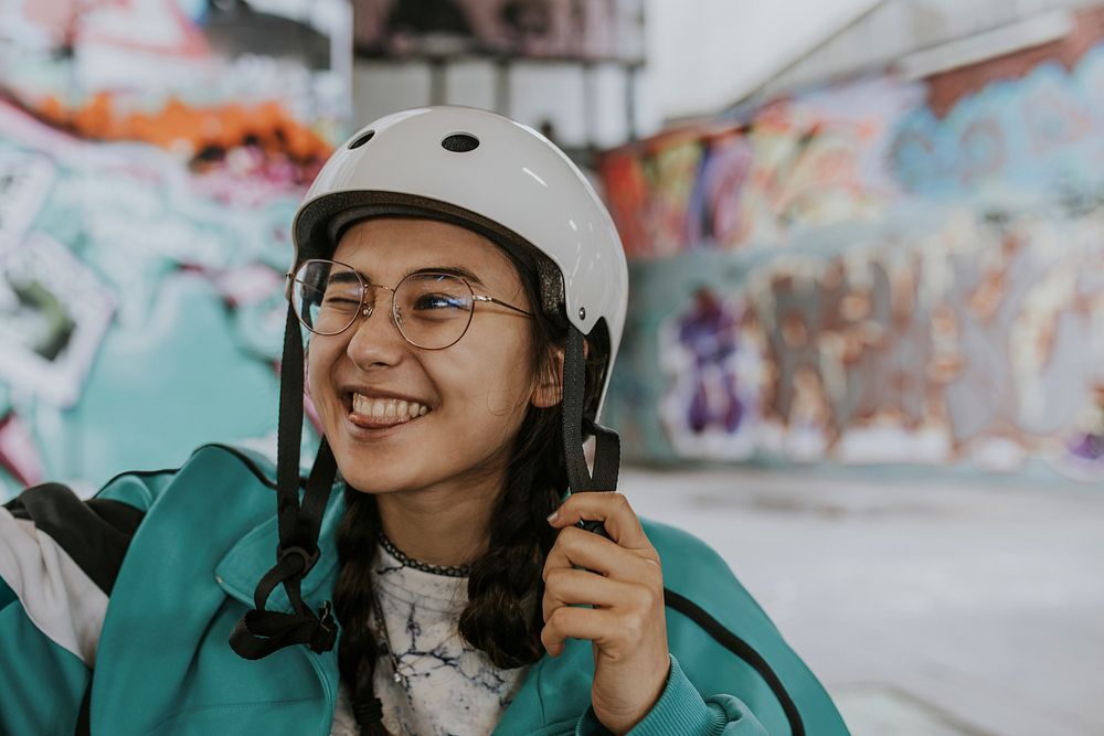 Cheerful Asian woman wearing white skate helmet