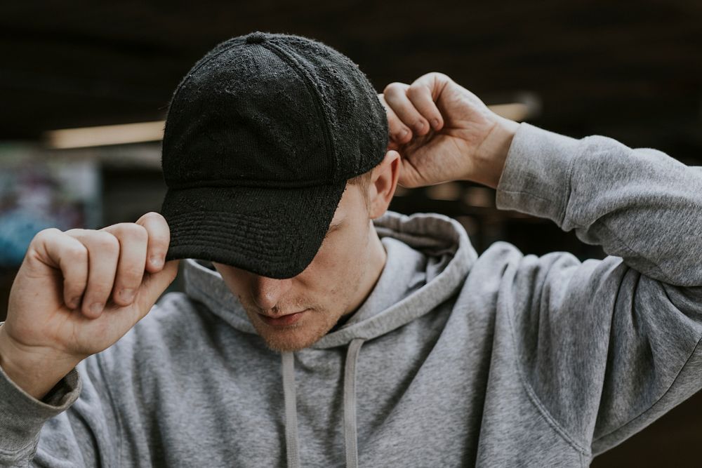 Man in gray hoodie wearing black cap