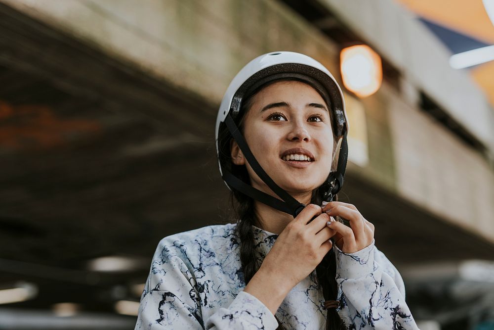 Cheerful woman wearing white skate helmet, sports safety equipment