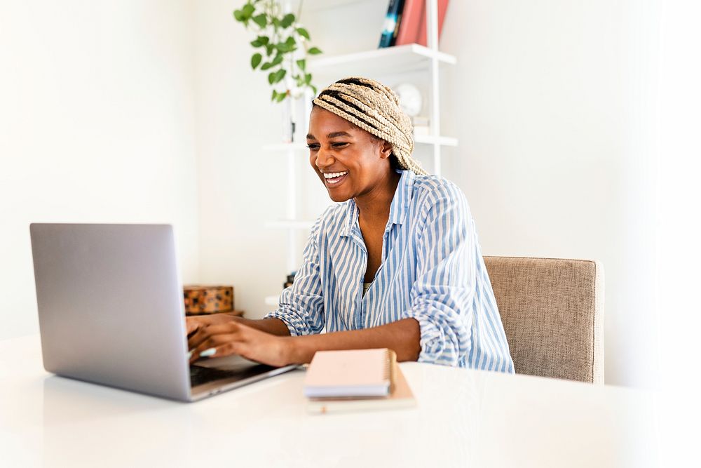 Black woman laughing during online meeting on laptop