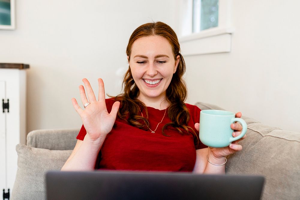 Woman working from home, waving during online meeting image