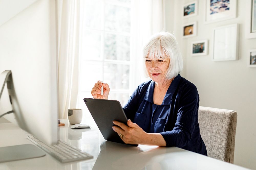 Senior successful businesswoman planning project on tablet, home office image
