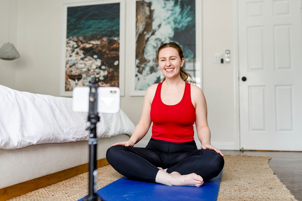 Woman yoga instructor live streaming on mobile phone