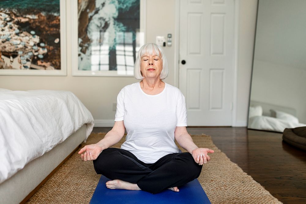 Old woman meditating, health and wellness concept 