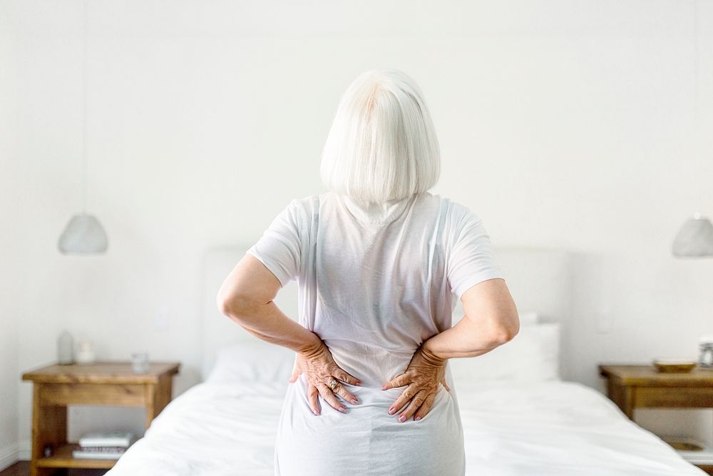 Senior woman suffering from back pain, health issue concept image