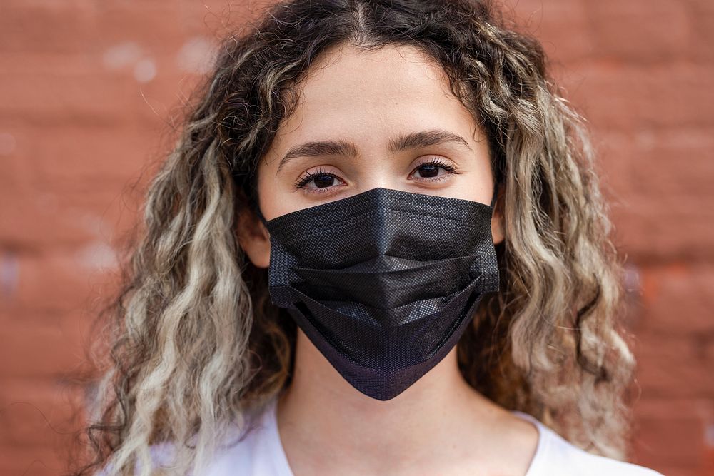 Blond woman wearing black face mask, the new normal lifestyle