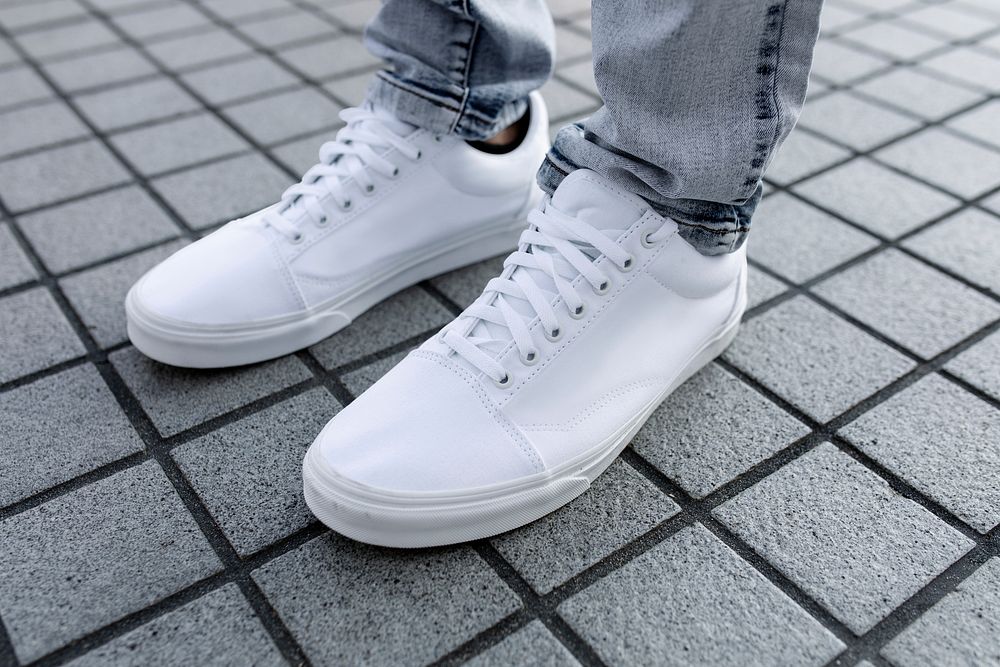 Plain white sneaker, men's footwear on a grey tiled floor