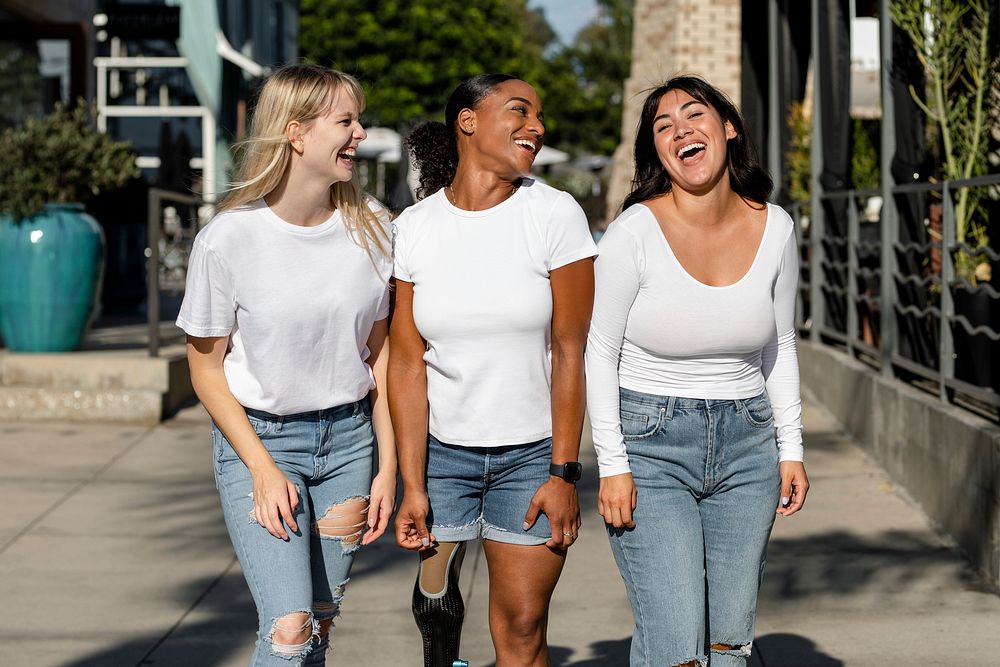 Three mixed race women, wearing plain white tshirts, community of inclusion & equality