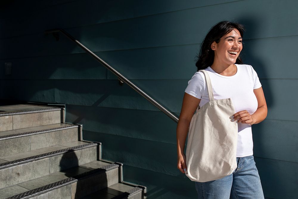 Confident Latina woman with a plain white tote bag, university campus staircase